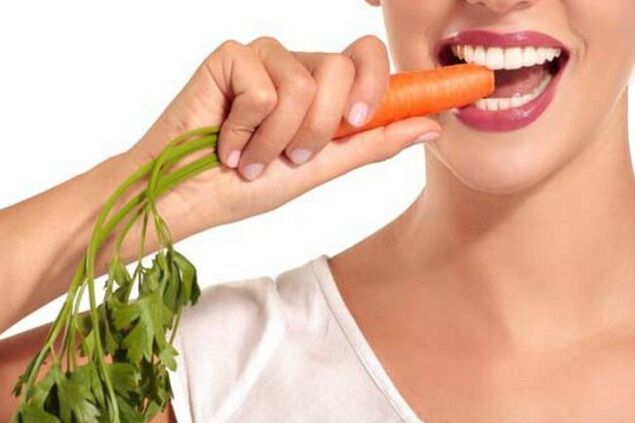 The girl eats raw carrots
